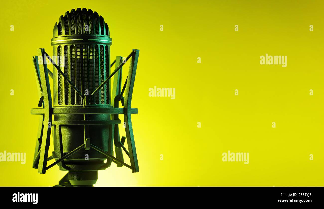 Un microfono a nastro retrò classico con uno sfondo giallo vivace con spazio di copia per il testo Foto Stock