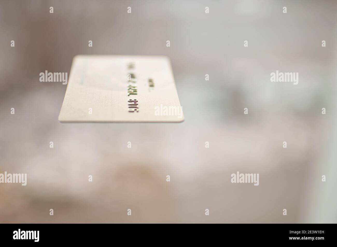 carta bancaria di colore oro su sfondo beige colore nell'aria Foto Stock