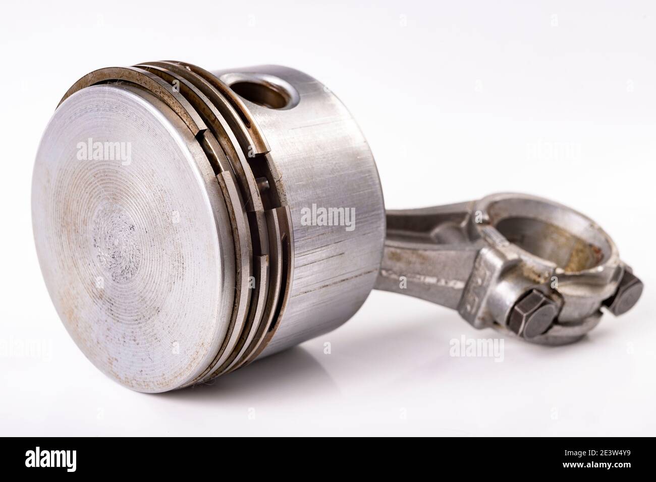 Pistone e biella di un piccolo motore a combustione interna. Pezzi di ricambio per la riparazione e la rigenerazione del motore. Sfondo chiaro. Foto Stock