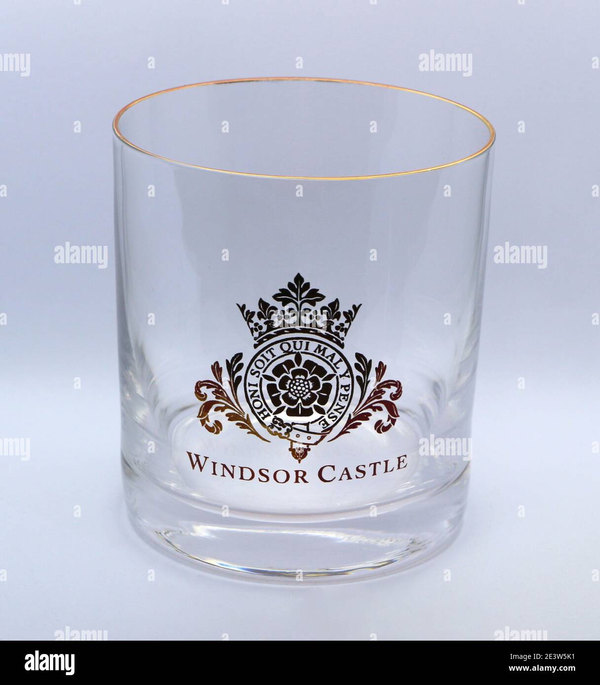Foto di un bicchiere di whisky di vetro trasparente come souvenir dal Castello di Windsor, Berkshire, Inghilterra, Regno Unito, con un bordo e uno stemma dorati su sfondo bianco Foto Stock