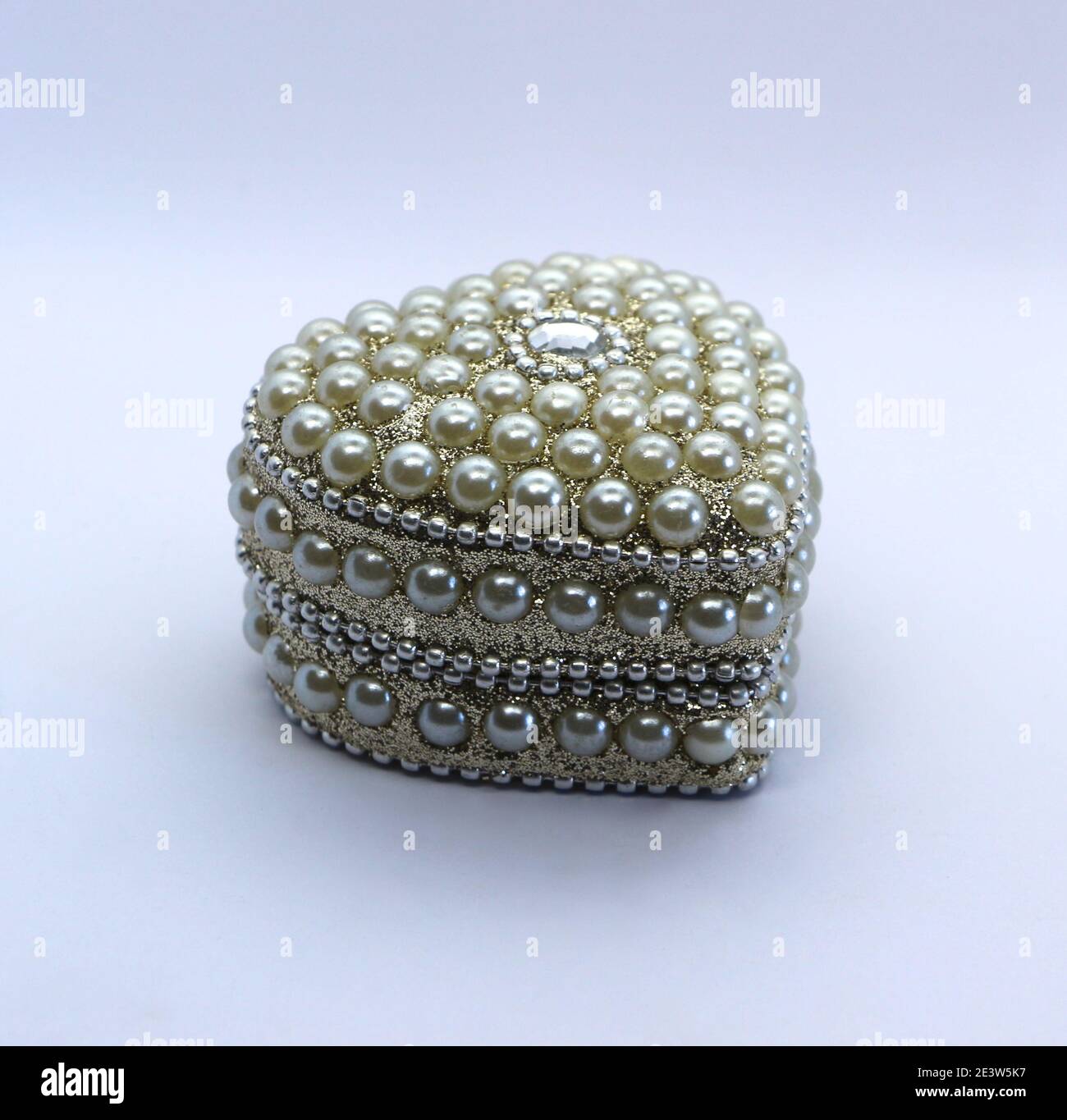 Foto di una piccola scatola di metallo a forma di cuore decorata con un diamante e finte perle San Valentino giorno presente Foto Stock