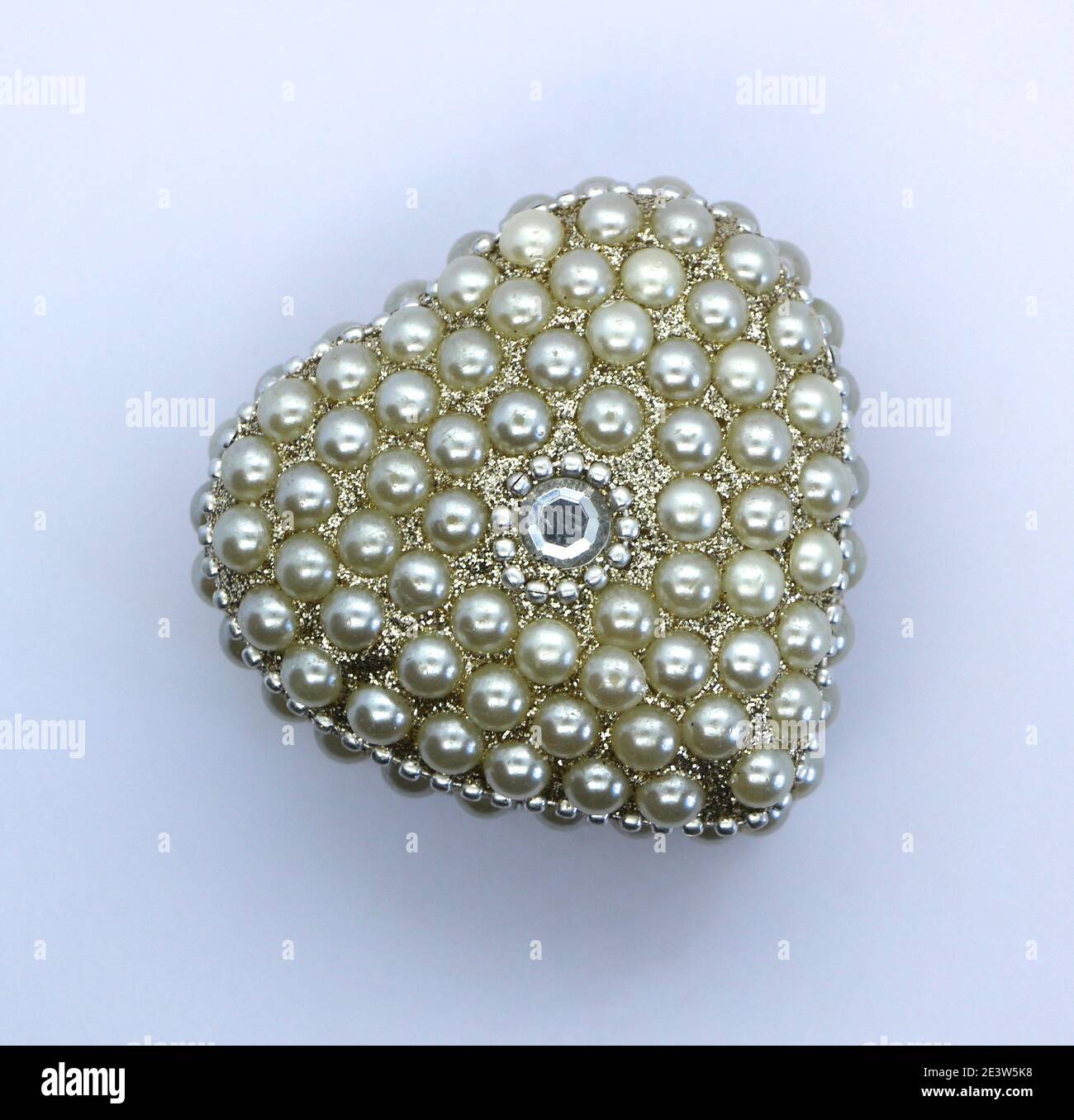 Foto di una piccola scatola di metallo a forma di cuore decorata con un diamante e finte perle San Valentino giorno presente visto dall'alto Foto Stock