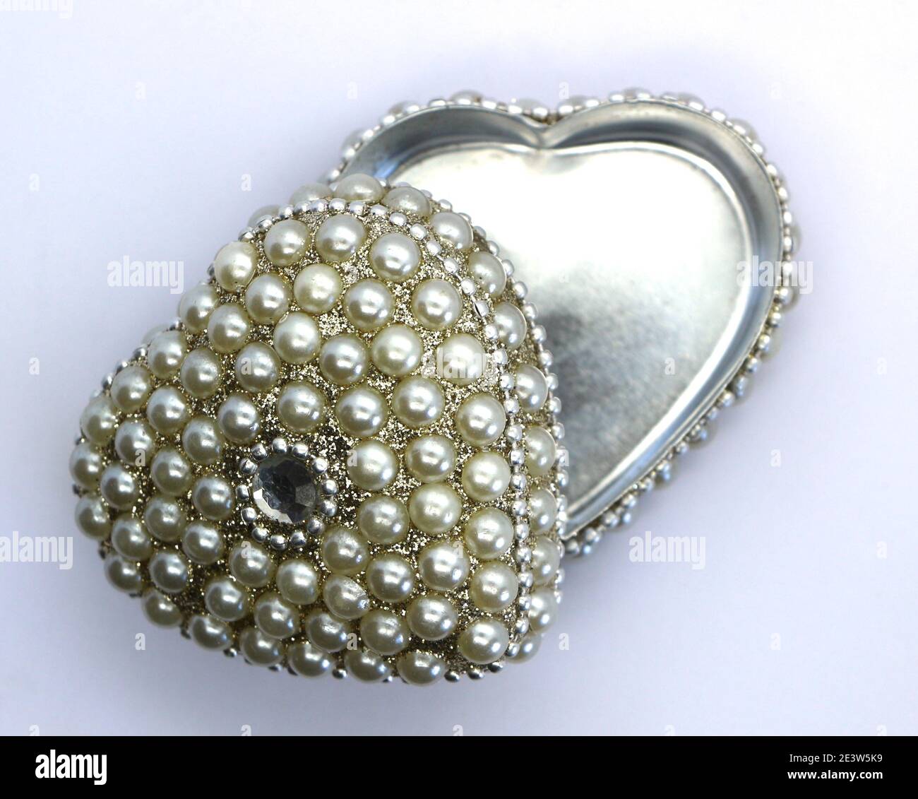 Foto di una piccola scatola di metallo a forma di cuore decorata con un diamante e finte perle San Valentino giorno presente dall'alto e aperto Foto Stock