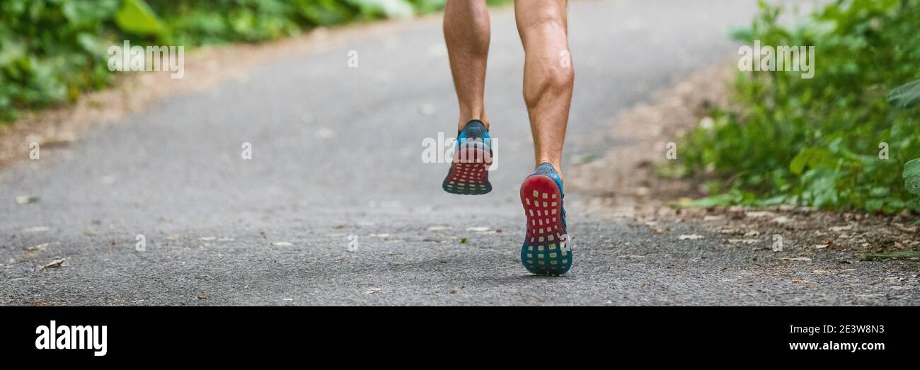 Scarpe da running banner panoramico di atleta uomo corridore sulla strada della città correre all'aperto panorama di piedi e gambe muscoli polpaccio. Foto Stock