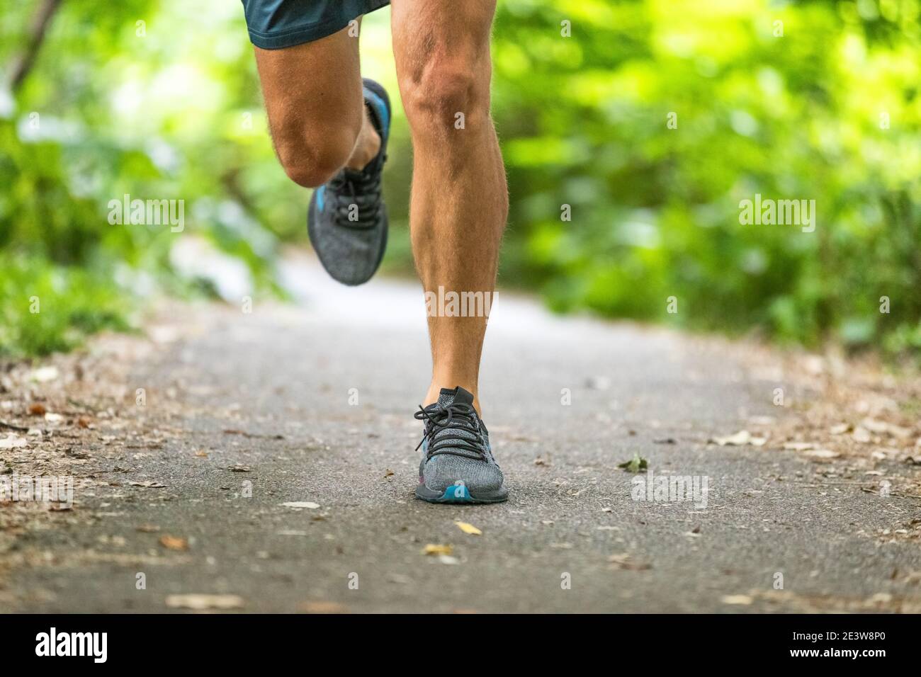 Running man Runner athlete allenamento jogging all'aperto sul percorso del parco cittadino con scarpe da running closeup di piedi e gambe. Foto Stock