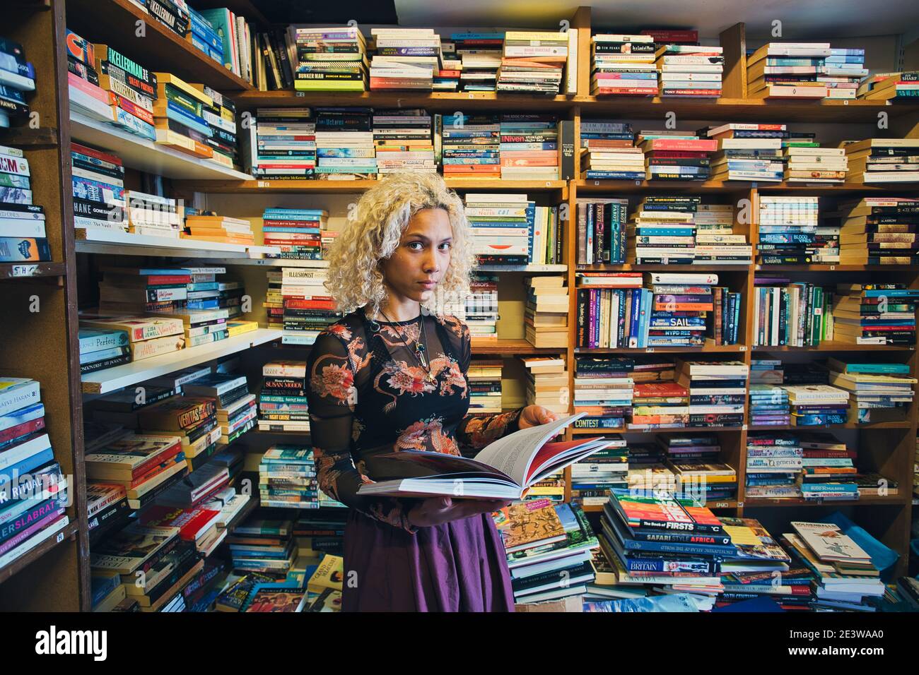 donna che tiene il libro in libreria Foto Stock