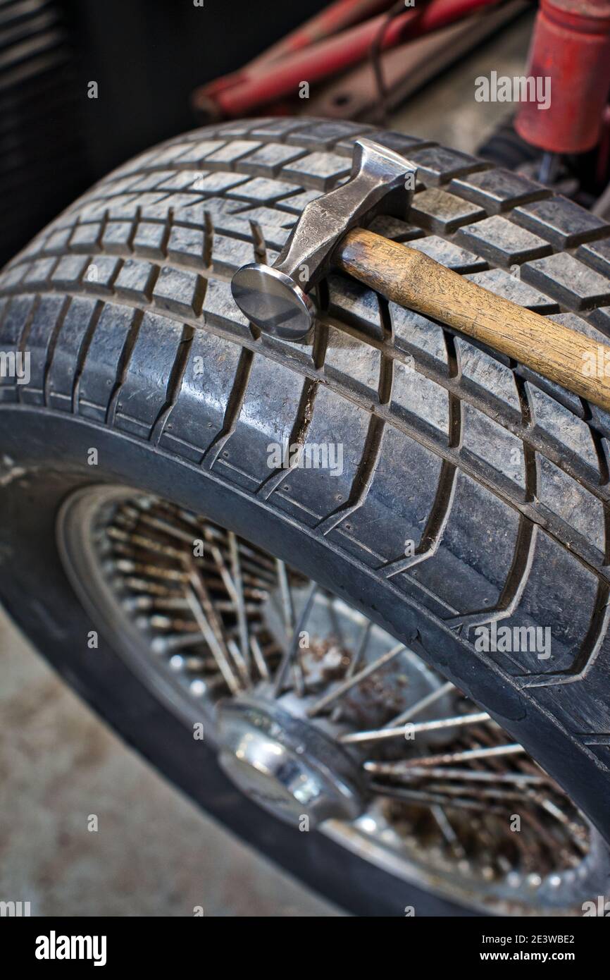 vecchio martello in officina su ruote e pneumatici. Foto Stock