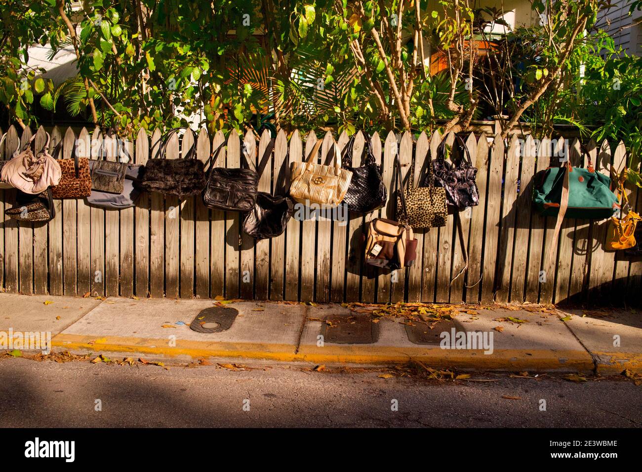 Borse appendenti su recinto di picket di legno grezzo a Key West, FL, USA. Famosa destinazione posizione. Foto Stock