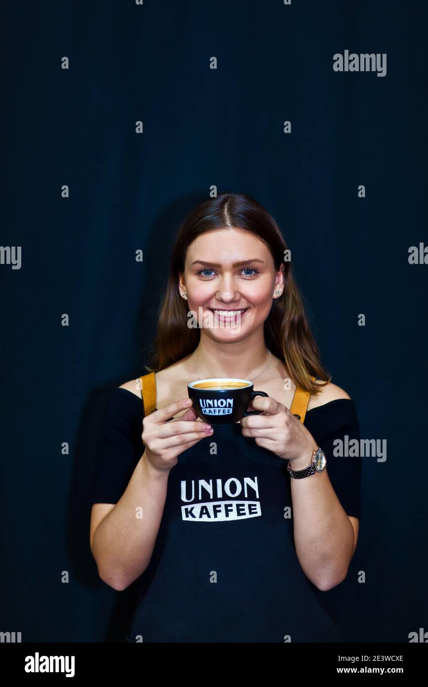 Donna che mantiene tazza di cappuccino con latte art Foto Stock