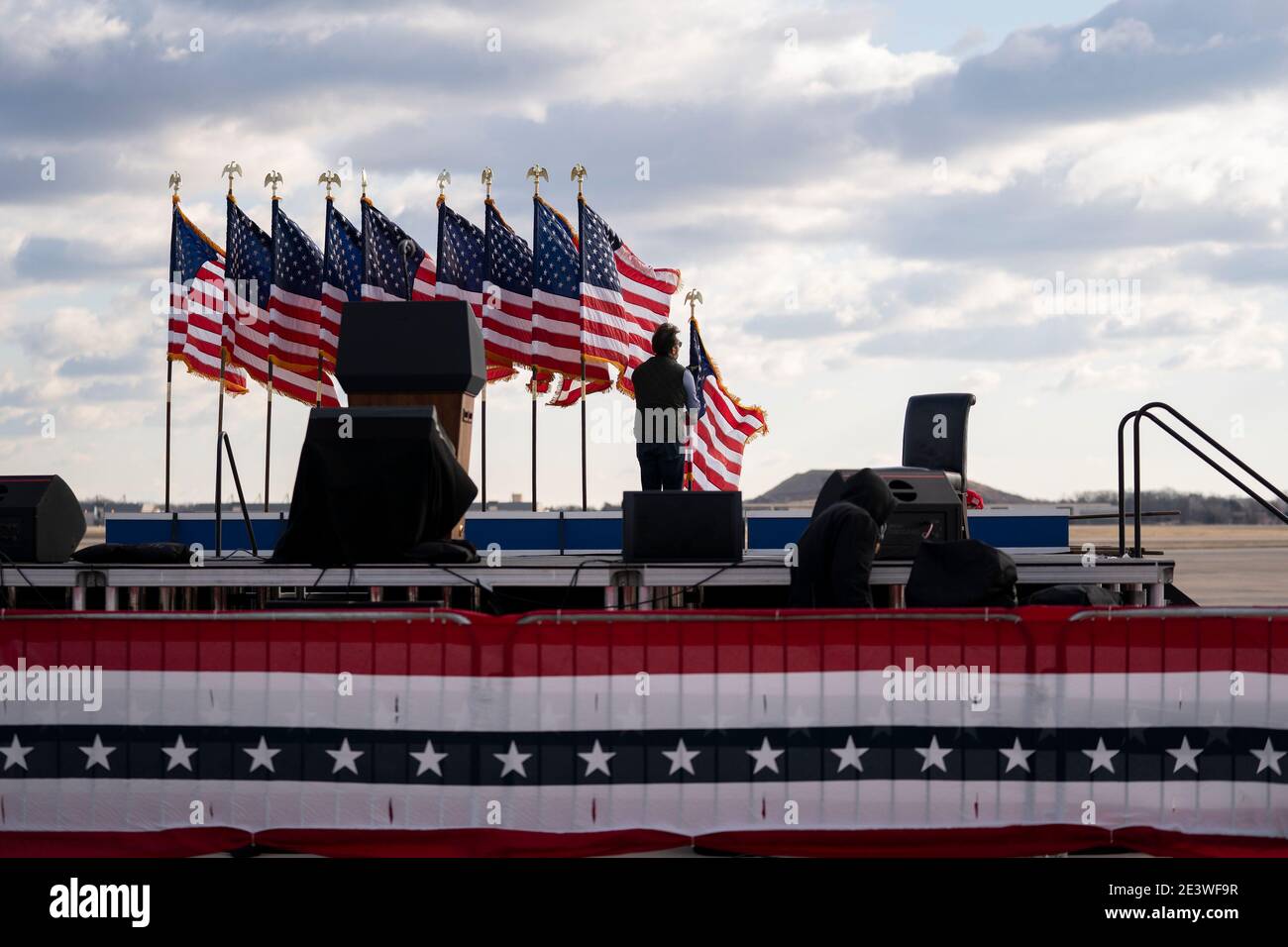 Un lavoratore rimuove le bandiere americane dopo una cerimonia di congedo alla base congiunta Andrews, Maryland, Stati Uniti, mercoledì 20 gennaio 2021. Trump abbandona Washington con gli americani più politicamente divisi e più propensi ad essere fuori lavoro che quando è arrivato, mentre attende il processo per il suo secondo impedimento - una fine ignominiosa a una delle presidenze più turbolente della storia americana. Fotografo: Stefani Reynolds/Bloomberg/MediaPunch Foto Stock