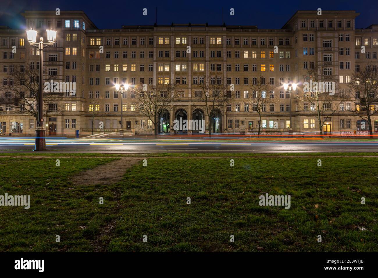 In serata, i sentieri leggeri delle auto si aggirano su Frankfurter Allee a Berlino-Friedrichshain. L'architettura sociale realistica del condominio Foto Stock