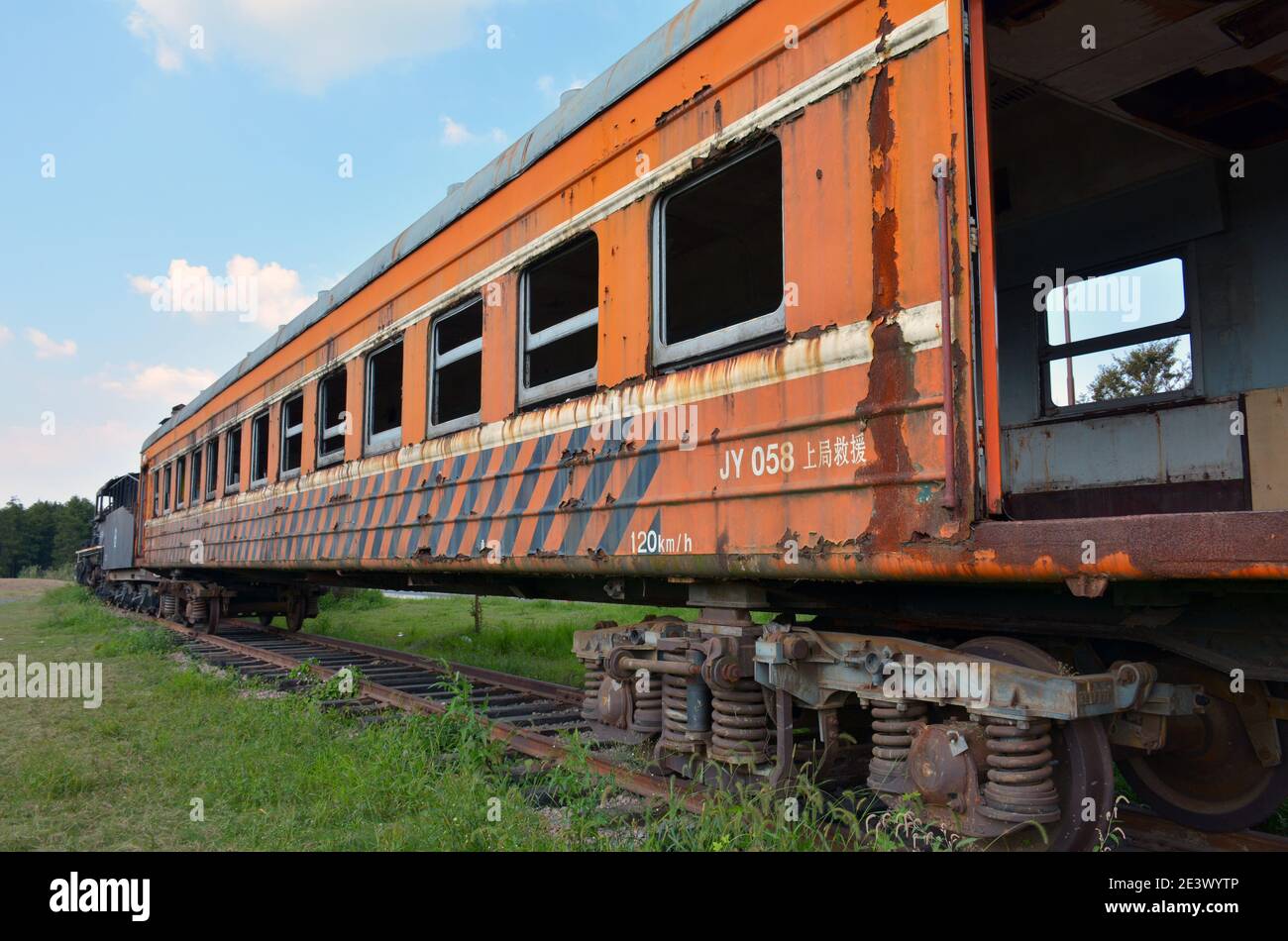 Vecchio treno a vapore e carrozze sul lato della strada a Jiaxing, Cina. Abbandonato e lasciato agli elementi. Corroso, arrugginito e ben intemperie. Foto Stock