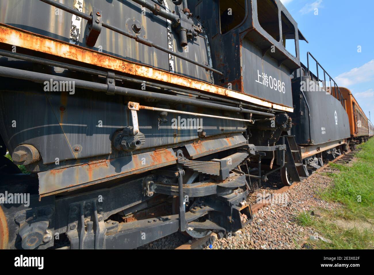 Vecchio treno a vapore e carrozze sul lato della strada a Jiaxing, Cina. Abbandonato e lasciato agli elementi. Corroso, arrugginito e ben intemperie. Foto Stock