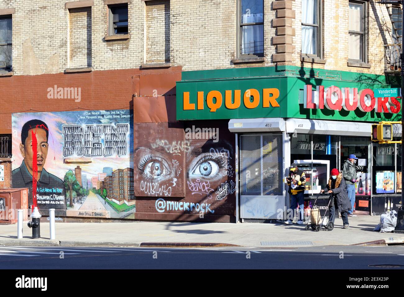 Un negozio di liquori, un murale memoriale ad un trafficante di droga ucciso, e la gente all'angolo di Myrtle e Vanderbilt Ave a Fort Greene/Clinton Hil Foto Stock