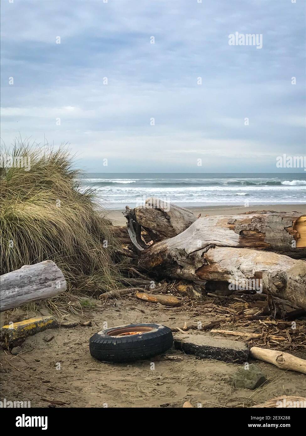 Vecchio pneumatico sulla bellissima spiaggia dell'Oregon, concetto di inquinamento Foto Stock