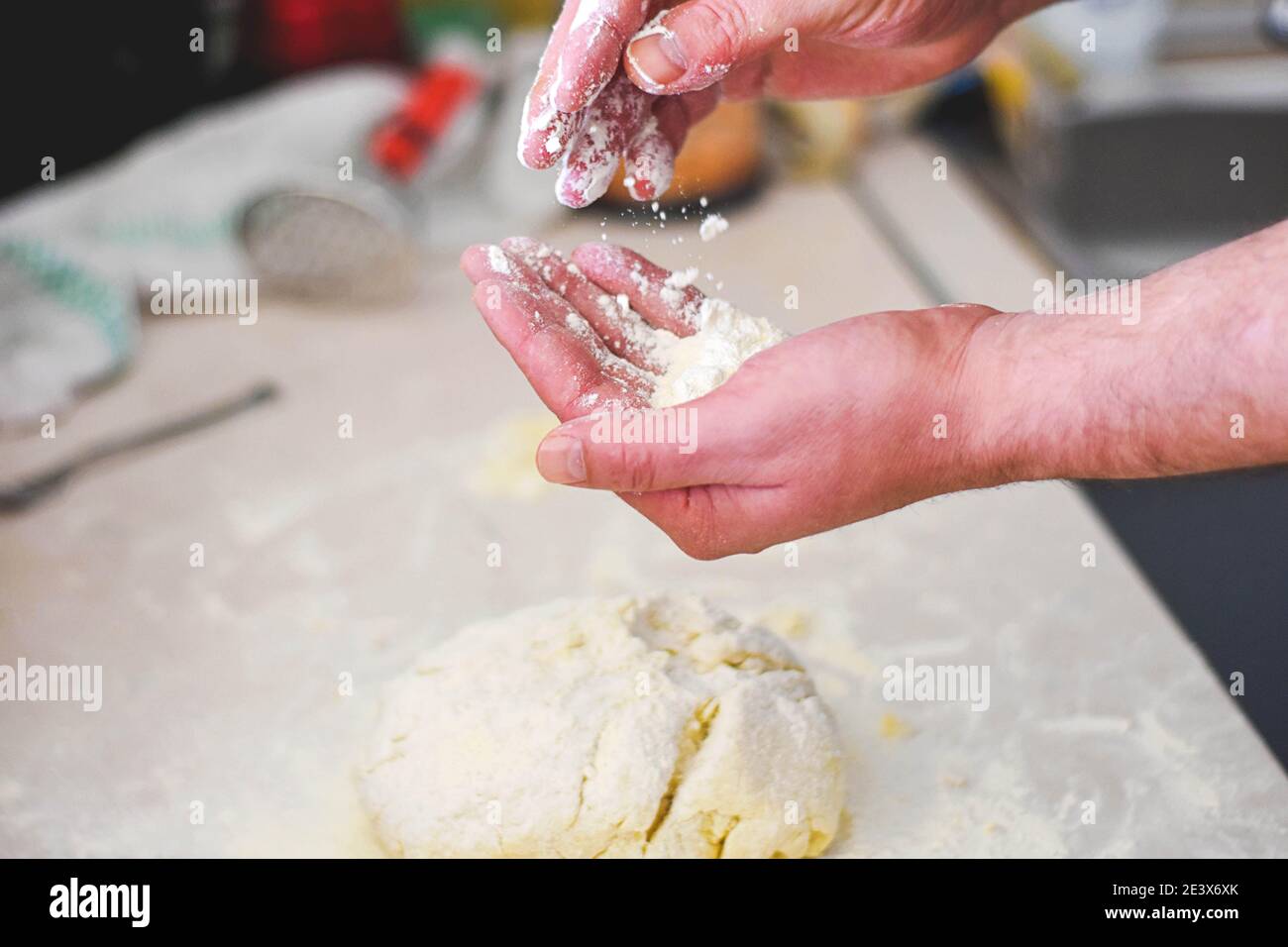 Primo piano le mani umane che fanno la pasta da pasta cruda / processo di preparazione del pane. Primo piano dell'impasto per impastare le mani dell'uomo. Foto Stock