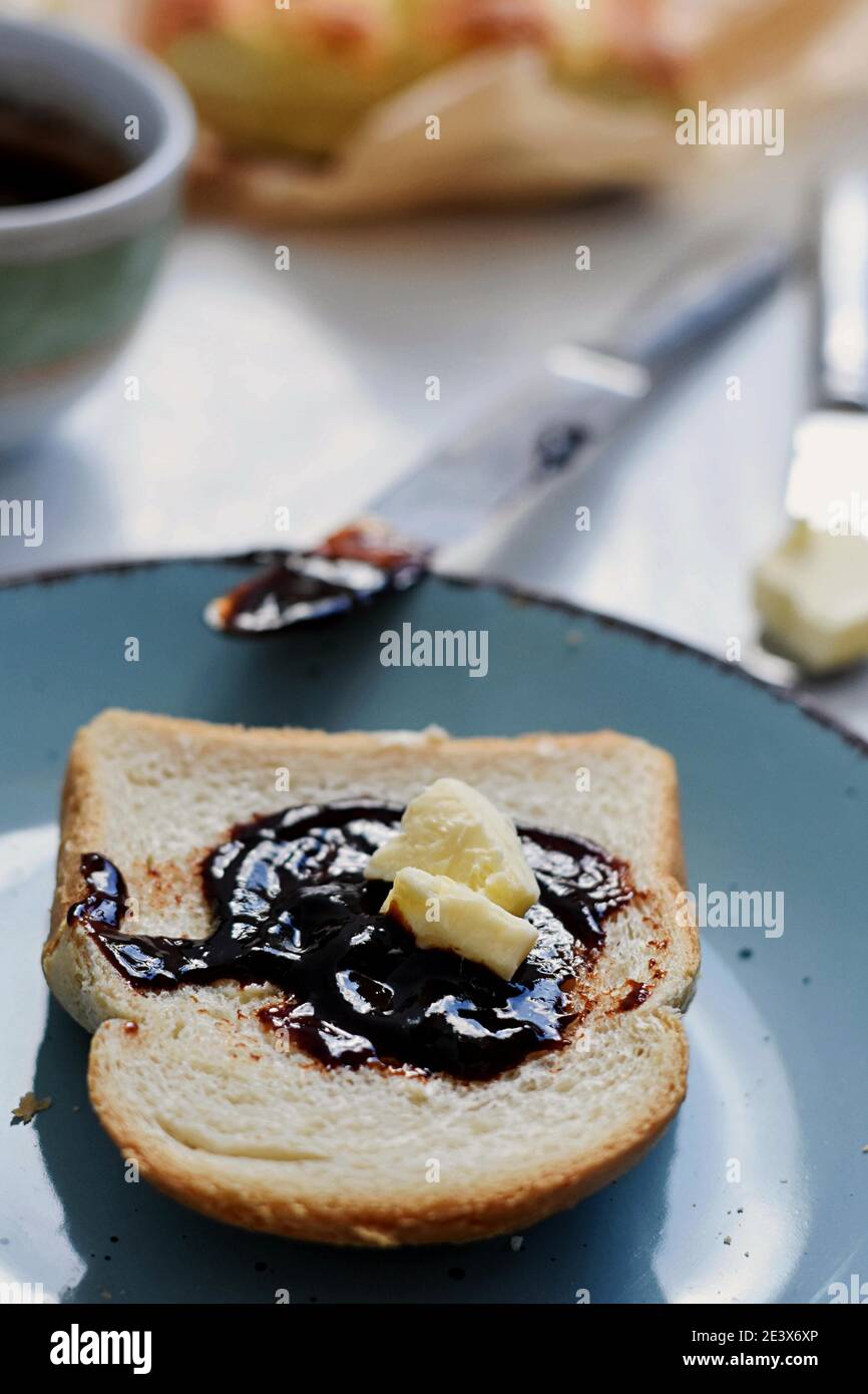 Pane tostato con marmellata di frutta/marmellata e burro/ tavolo per la colazione/ Foto Stock