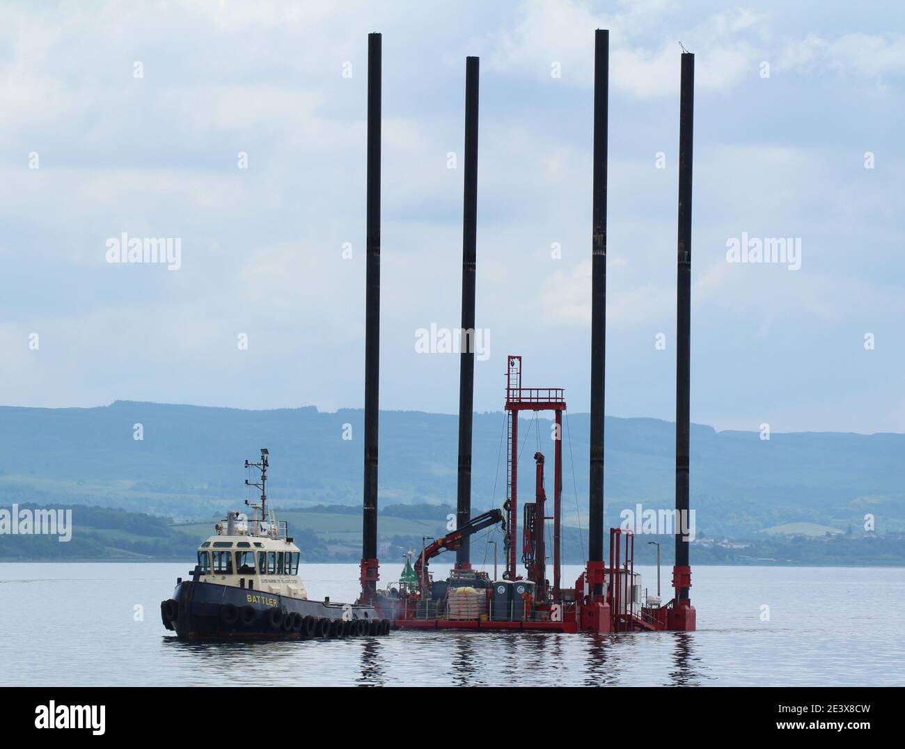 Battler, un rimorchiatore gestito da Clyde Marine Services, con sede a Greenock, sulle operazioni di traino con il martinetto di supporto di Fegro su chiatta Skate 3. Foto Stock