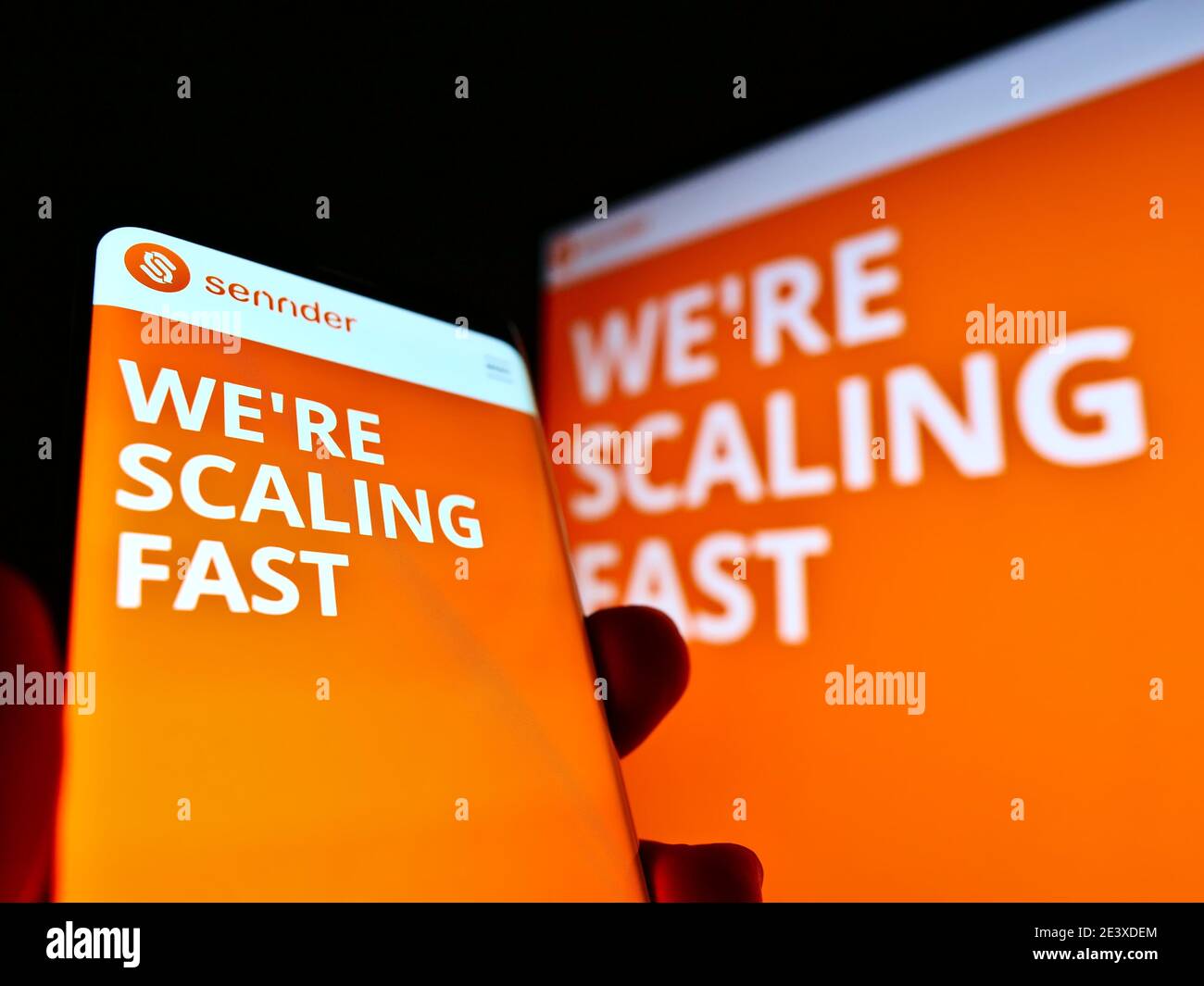 Persona che tiene il telefono mobile con il sito web della società di logistica tedesca Sennder GmbH in esposizione. Mettere a fuoco il logo nell'angolo in alto a sinistra dello schermo del dispositivo. Foto Stock