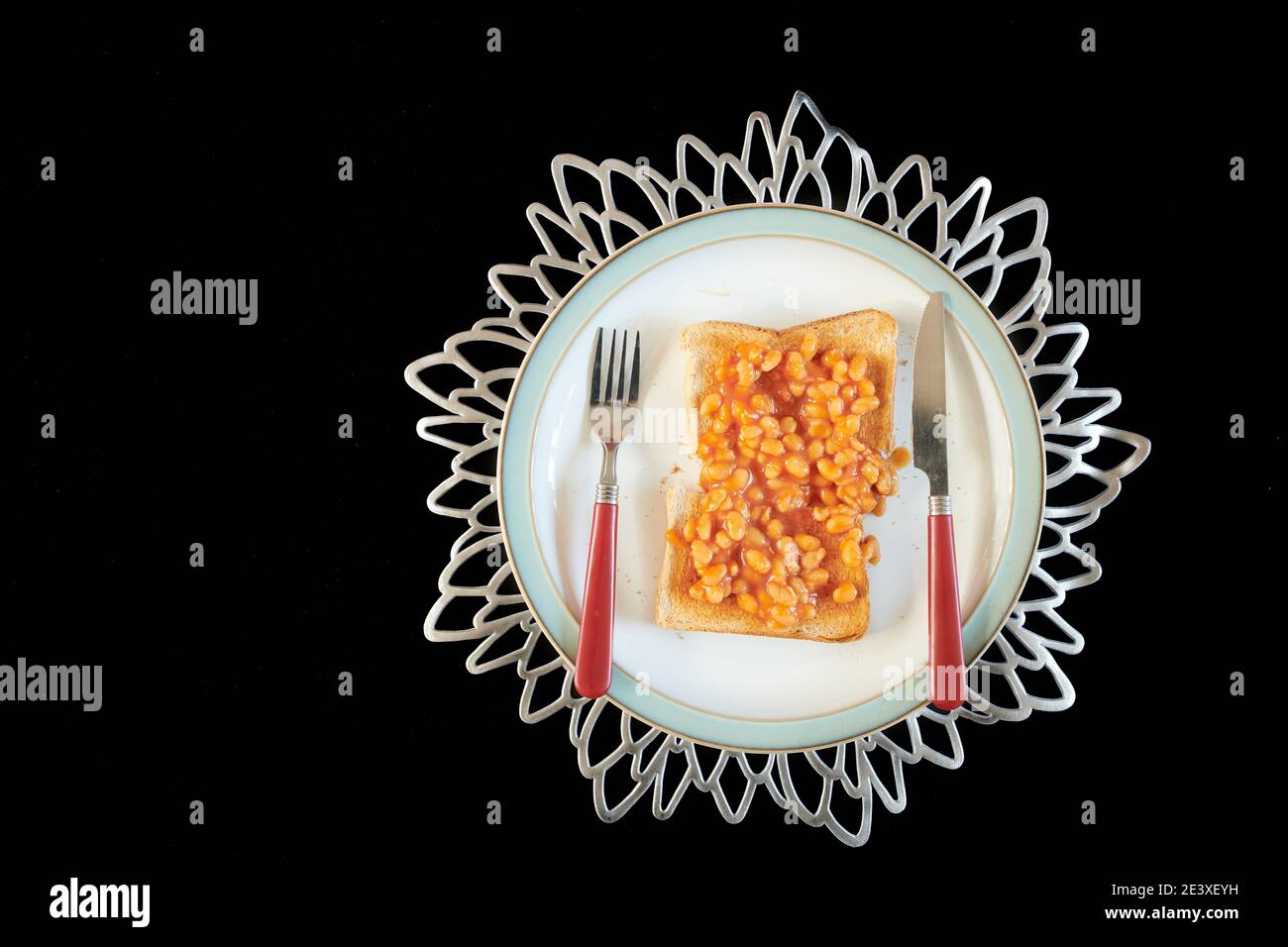 Fagioli cotti in salsa di pomodoro su toast marrone. Foto Stock