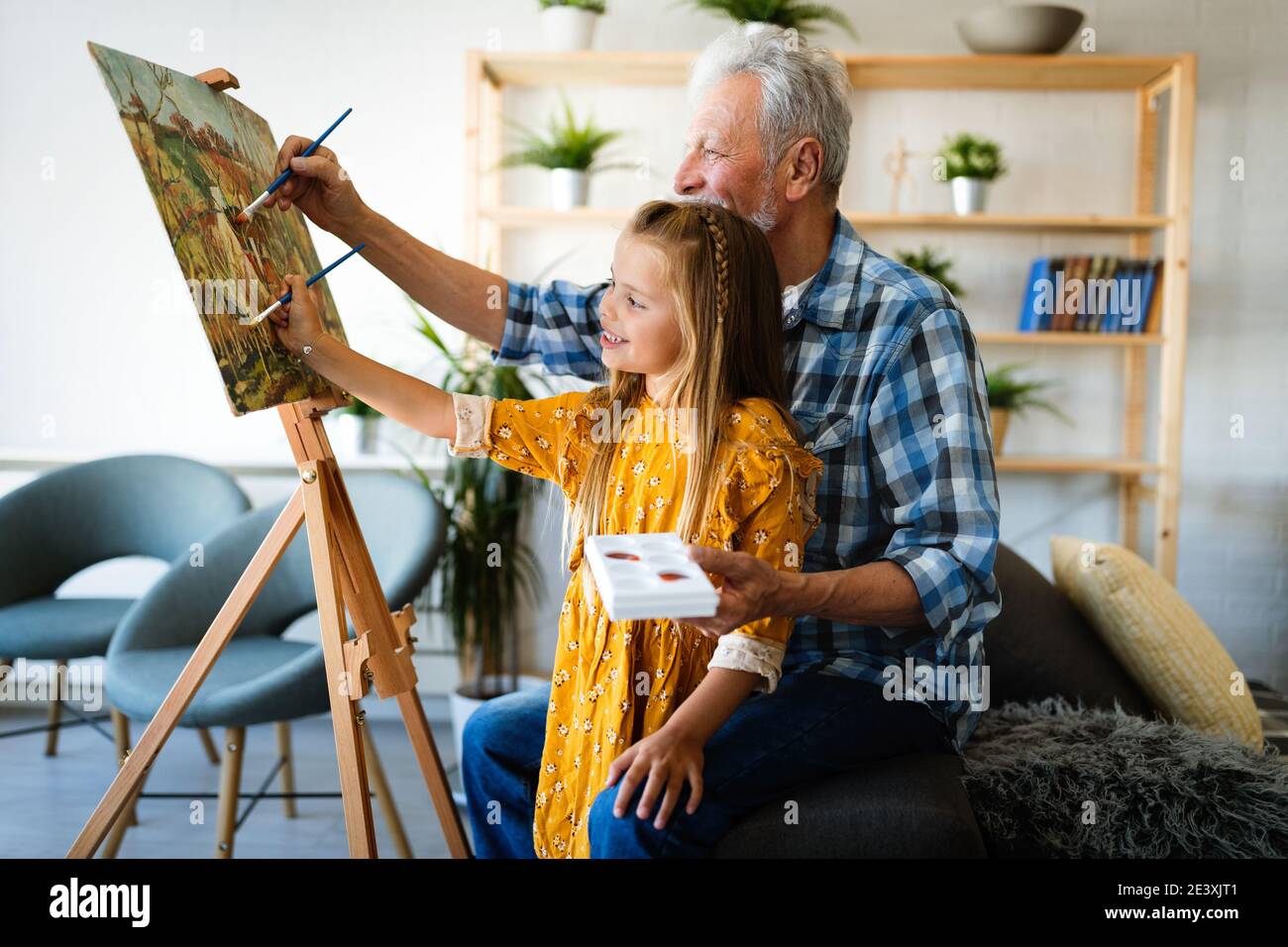 Senior uomo con bambino dipinto su tela. Nonno spendere tempo felice con il nipote. Foto Stock