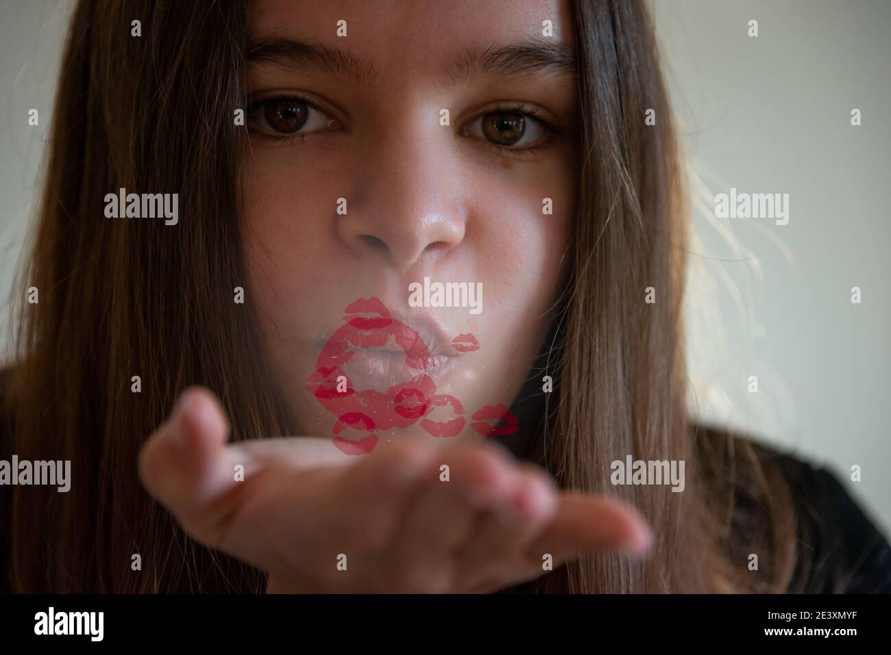giovane donna che soffia un bacio con le labbra rosse che escono dalla bocca, giorno di valentines bacio con divaricarsi sociale. Foto Stock