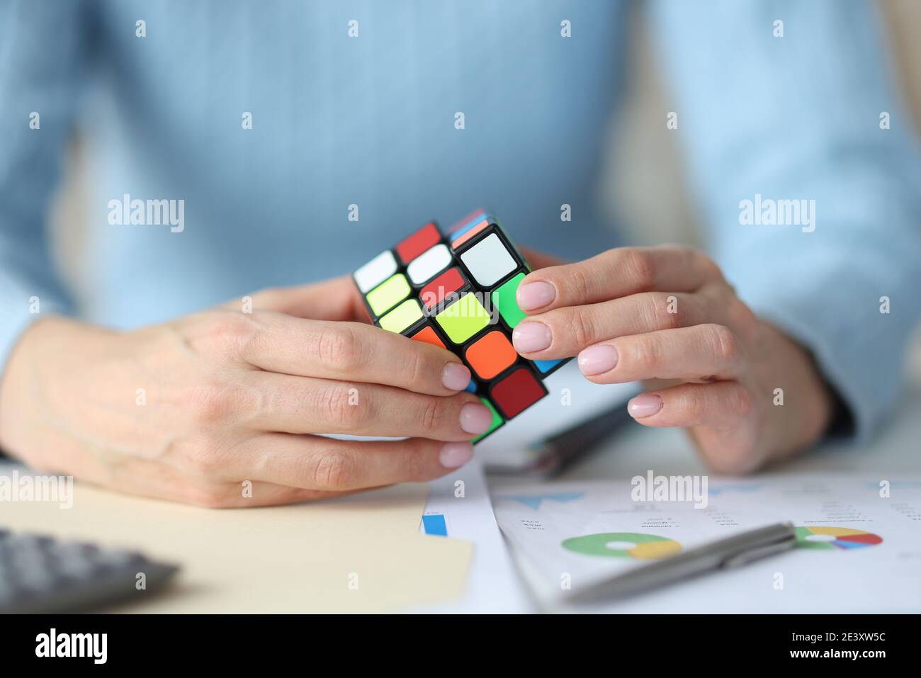Mani femminili che tengono il cubo di Rubik Foto Stock