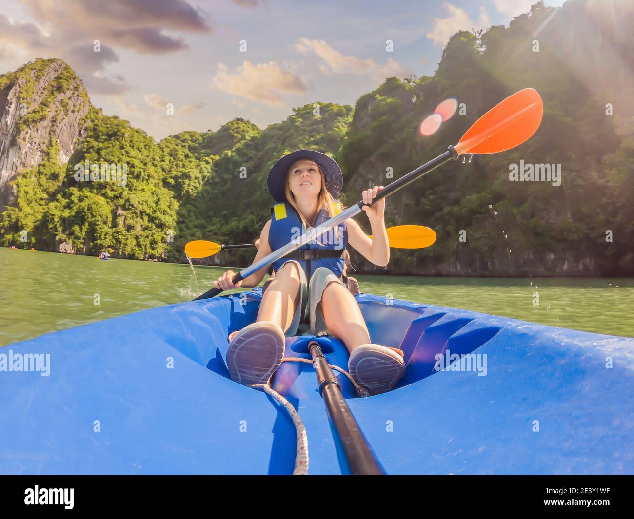 I viaggiatori di mamma, papà e figlio che girano su un kayak nella Baia di ha Long. Vietnam. Viaggio in Asia, emozione di felicità, concetto di vacanza estiva. Viaggiare con Foto Stock