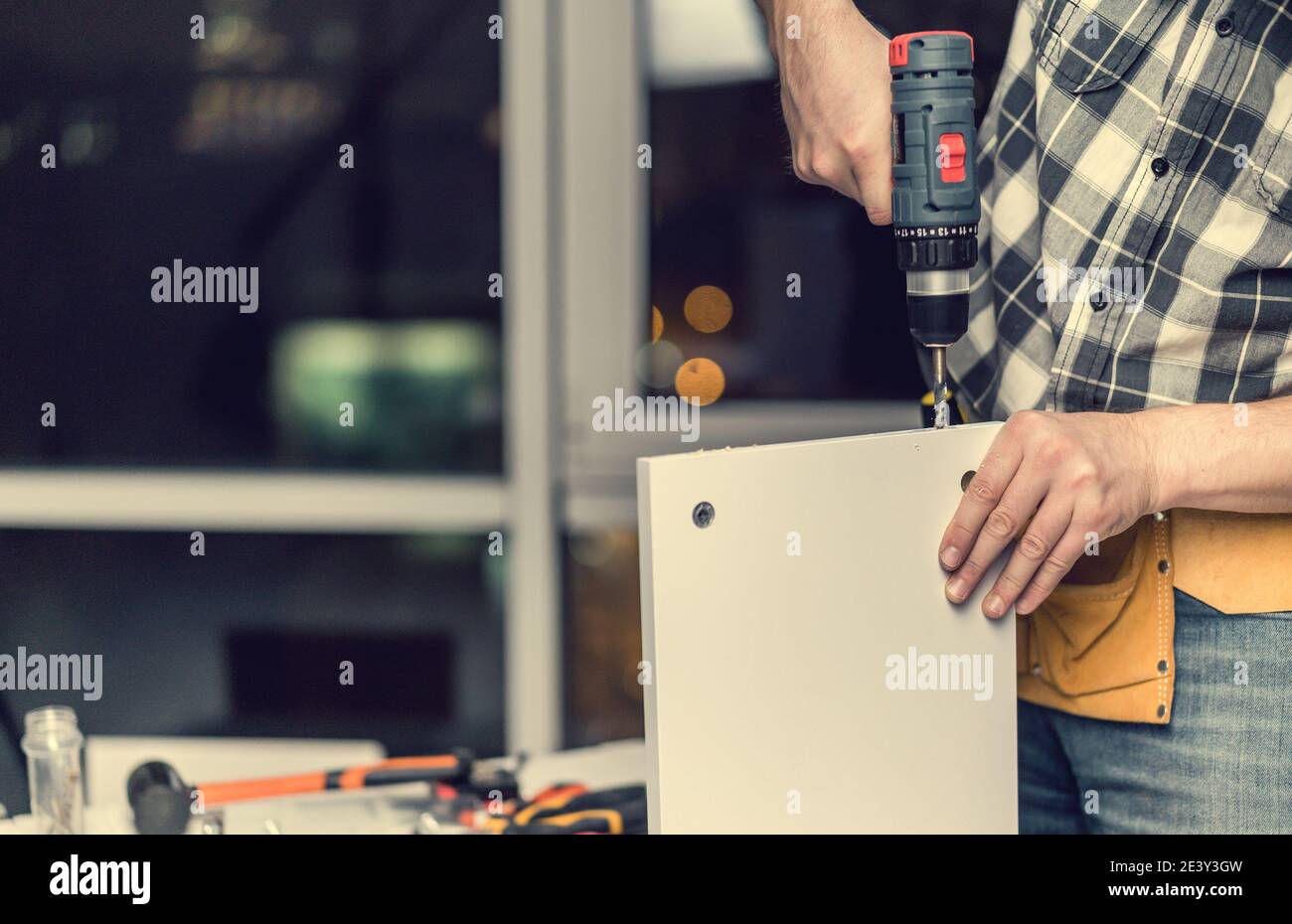 Uomo che lavora durante il processo di produzione di mobili Foto Stock