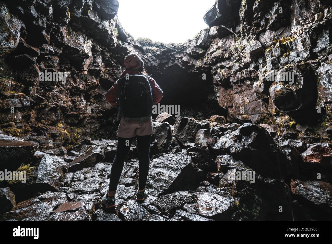 Donna viaggiatore esplorare il tunnel di lava in Islanda. Raufarholshellir è un bellissimo mondo nascosto di grotta. È una delle lava più lunghe e conosciute Foto Stock