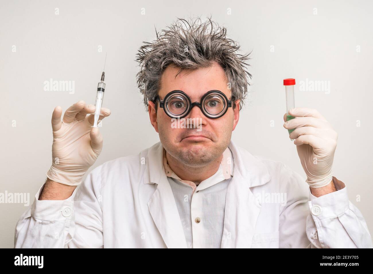 Scienziato pazzo con capelli grigi che eseguono esperimenti in laboratorio Foto Stock