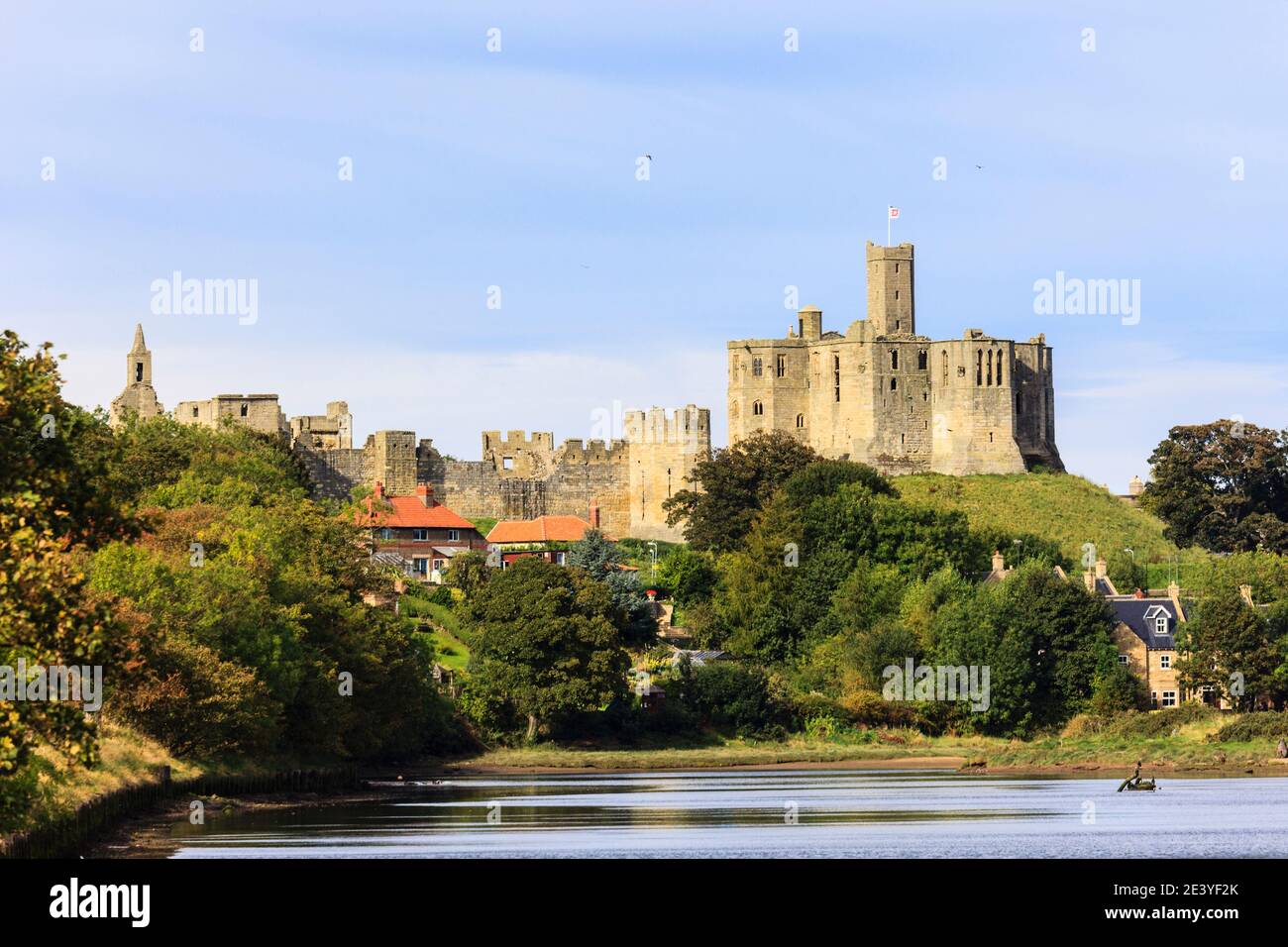 Vista lungo il fiume Coquet alle rovine del castello di Warkworth 15 ° secolo sopra il villaggio. Warkworth, Northumberland, Inghilterra, Regno Unito, Gran Bretagna Foto Stock