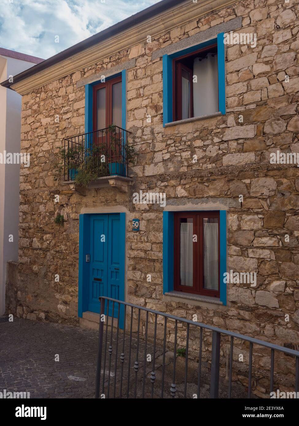 Antica casa in pietra con porte e finestre blu in stile mediterraneo nel  romantico villaggio di montagna Baunei Ogliastra, Sardegna, Italia Foto  stock - Alamy