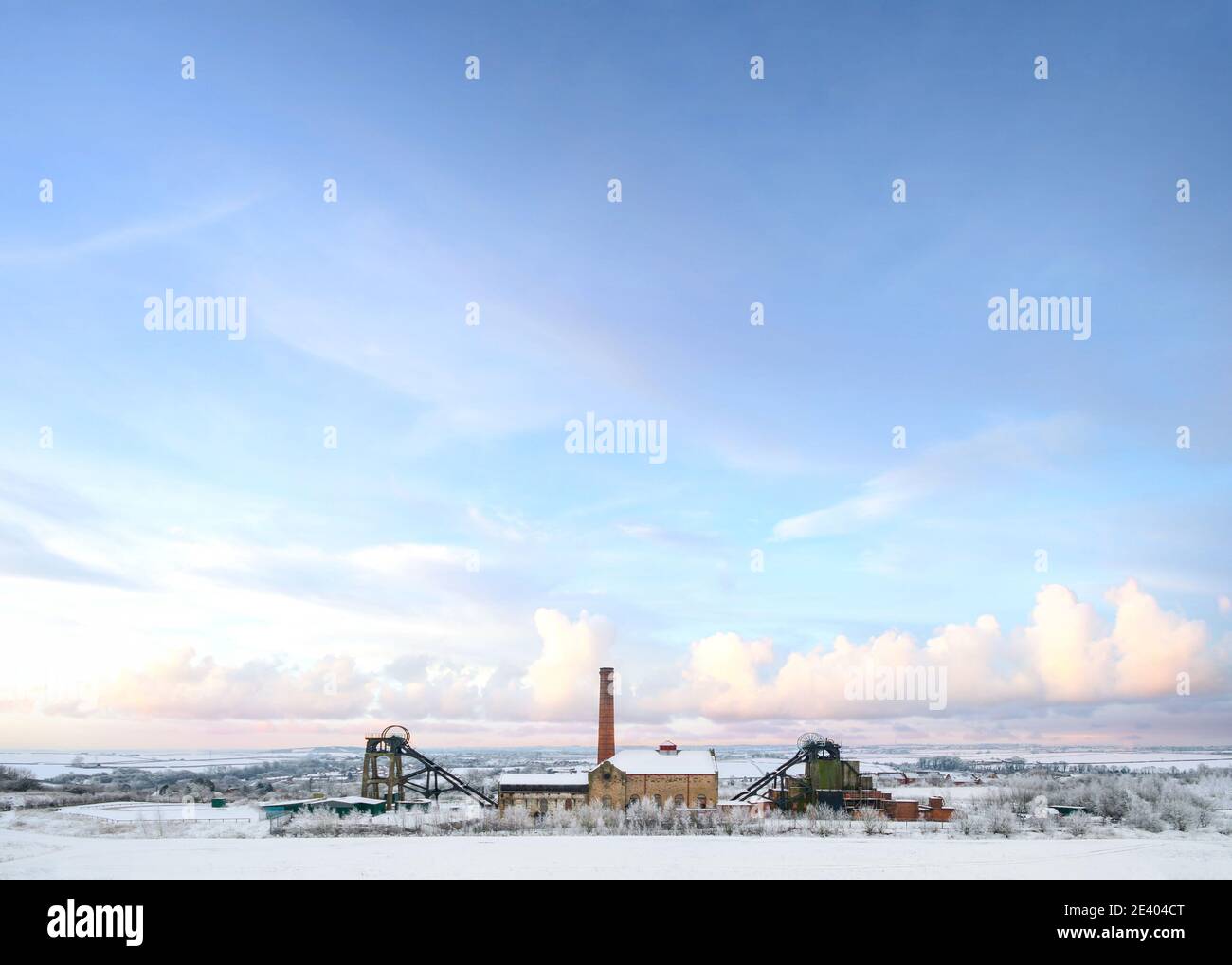 Vecchia miniera nazionale di carbone abbandonata in campagna con l'industria Casa motore ruota di avvolgimento neve autunno Natale inverno neve scena paesaggio Pleasley Foto Stock