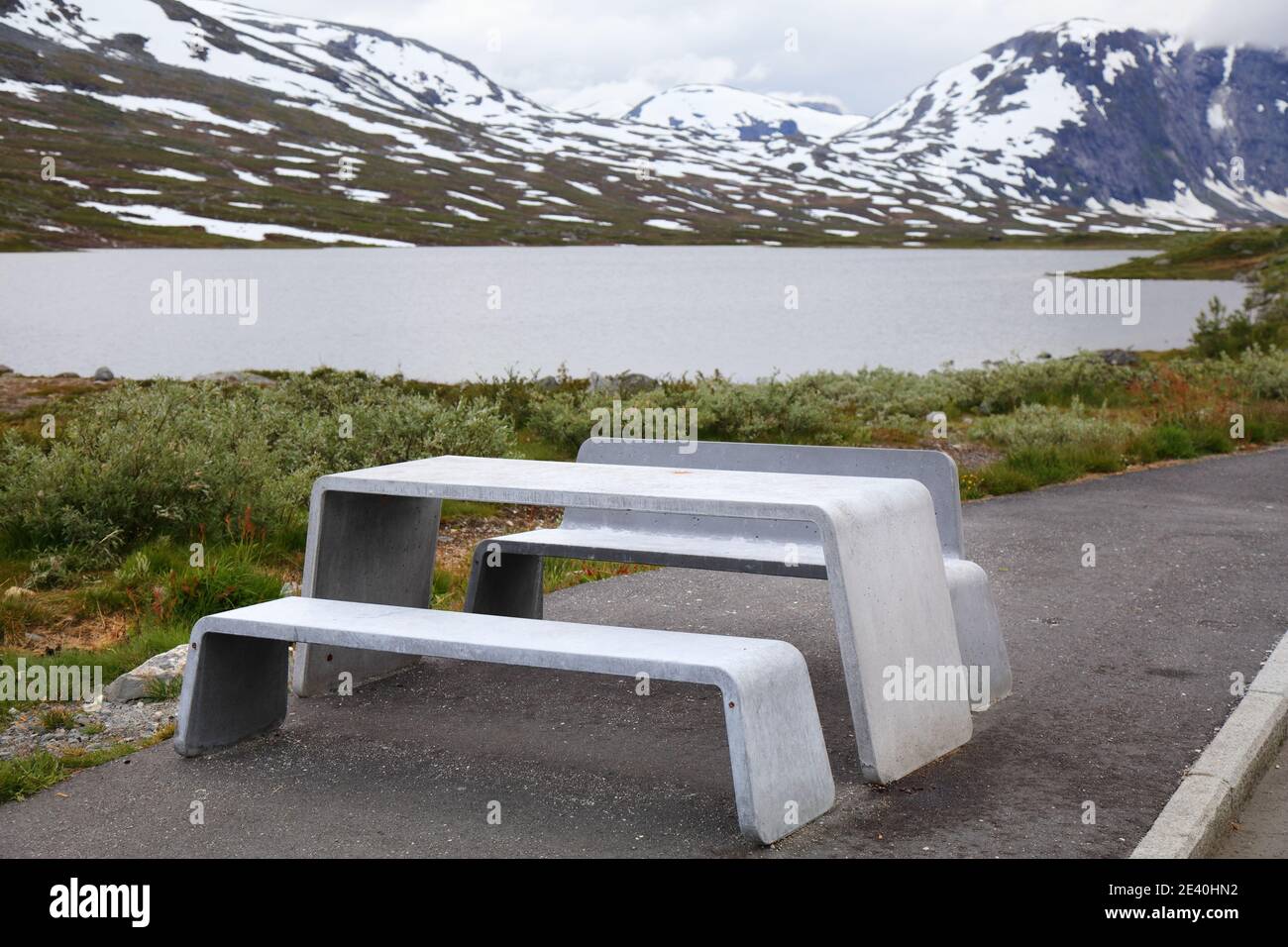Inverno in estate - neve in Norvegia. Sunnmore Alpi tavolo da picnic in un luogo di riposo. Foto Stock