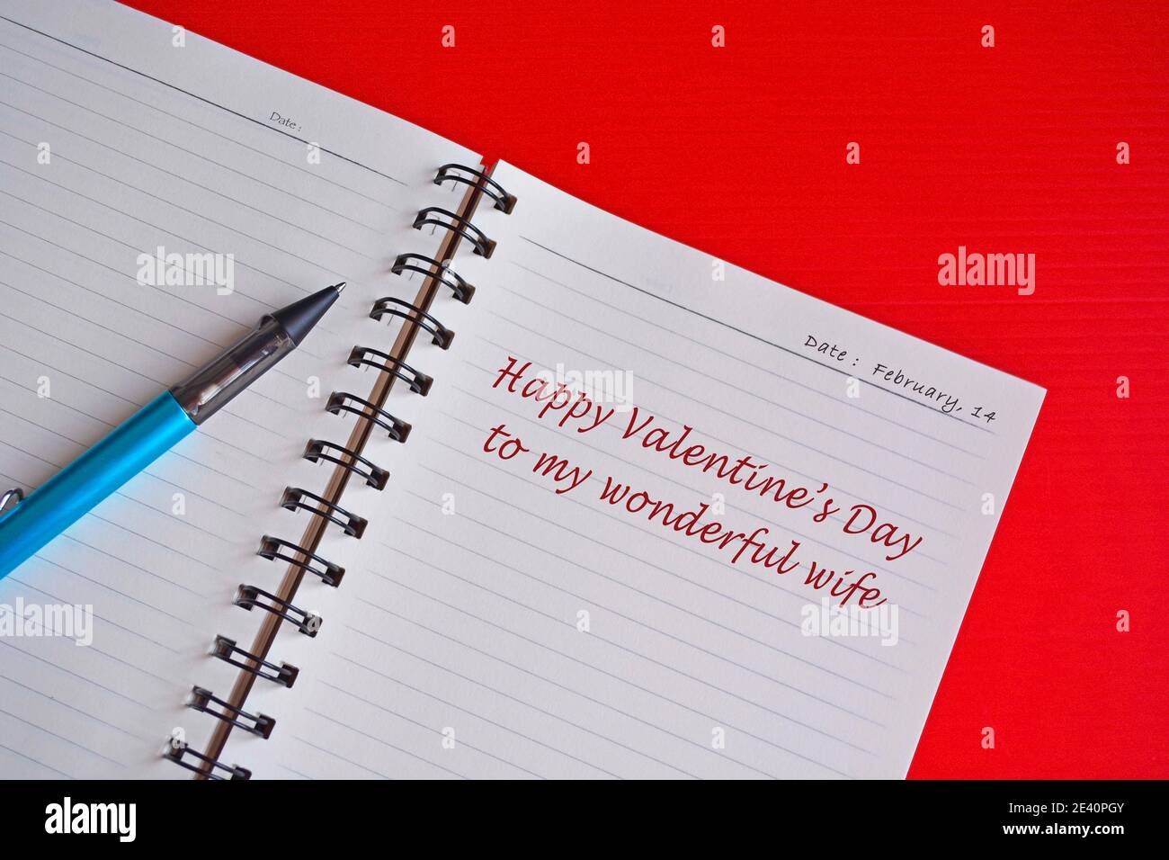 Testo su blocco note bianco con sfondo rosso. Concetto di San Valentino Foto Stock