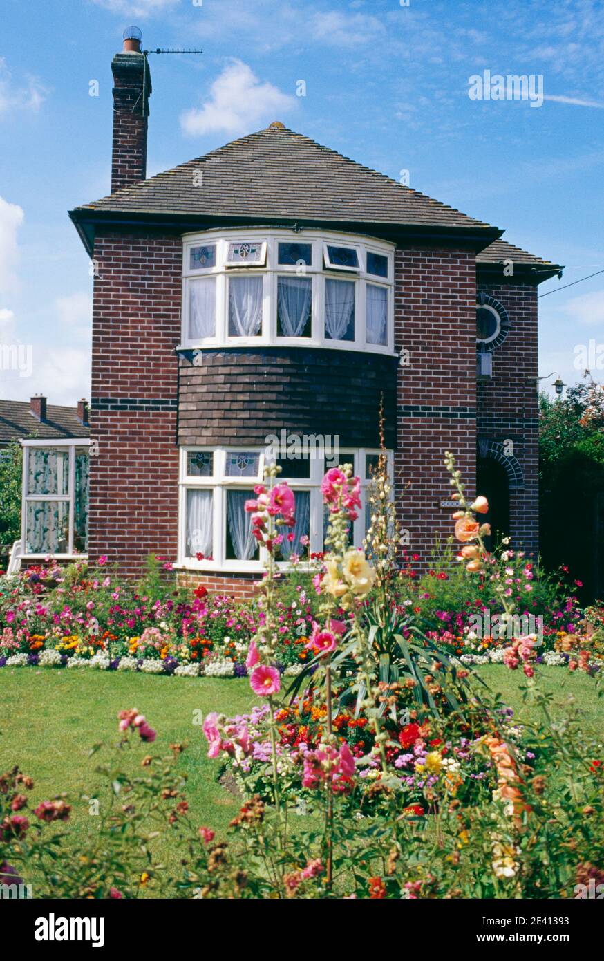 1920 / 30s casa indipendente di mattoni con giardino anteriore pieno di fiori evercreech somerset Foto Stock