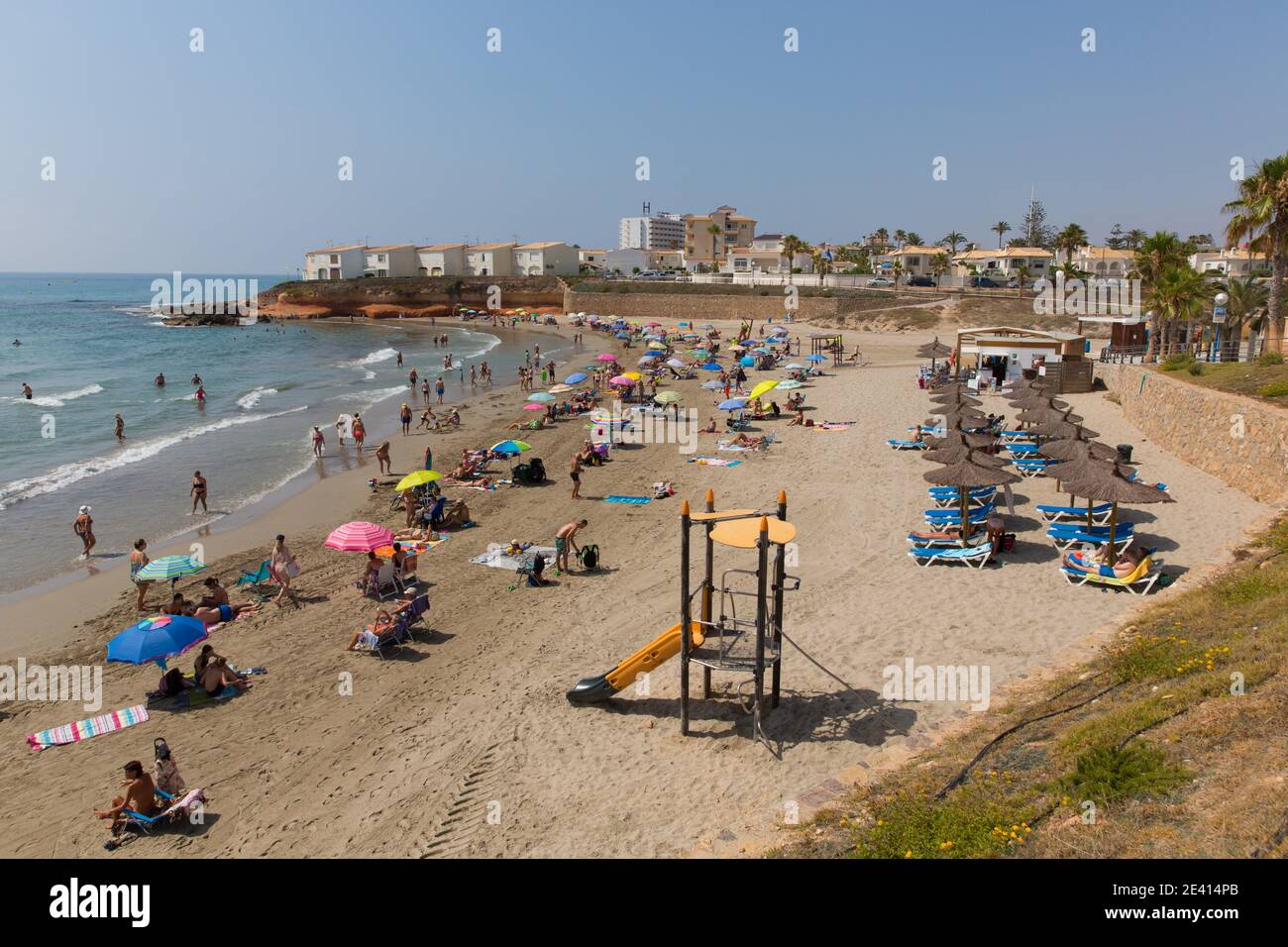 Playa Flamenca Spagna spiaggia con persone sotto il sole estivo Foto Stock
