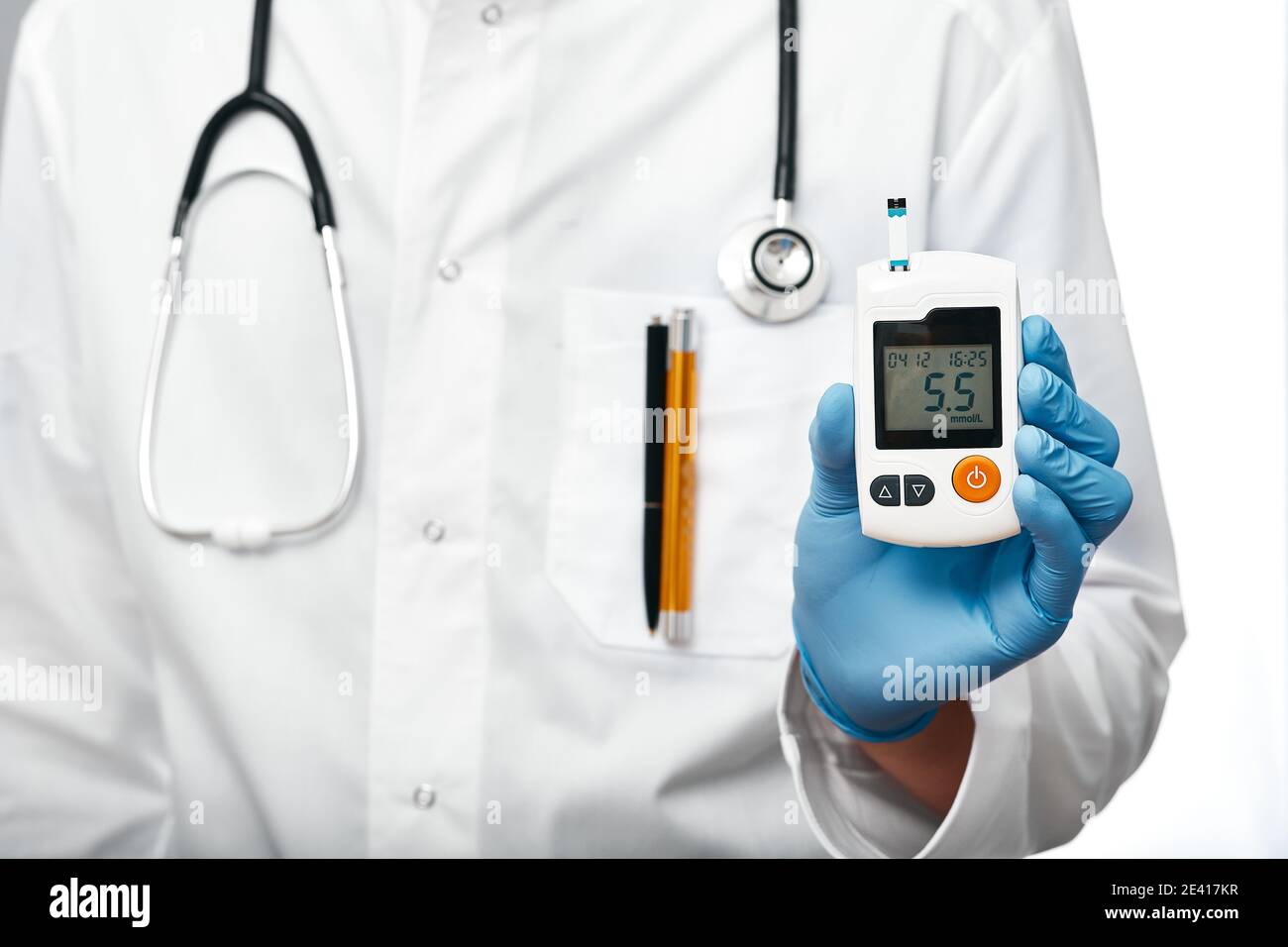 medico che tiene in mano il glucometro per misurare i livelli di glucosio nel sangue del paziente, primo piano Foto Stock