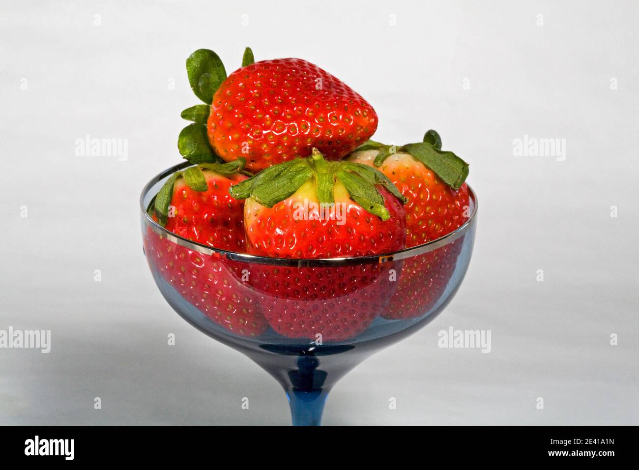 Fragole fresche, dolci e rosse direttamente dall'orto, in un bicchiere di champagne. Foto Stock