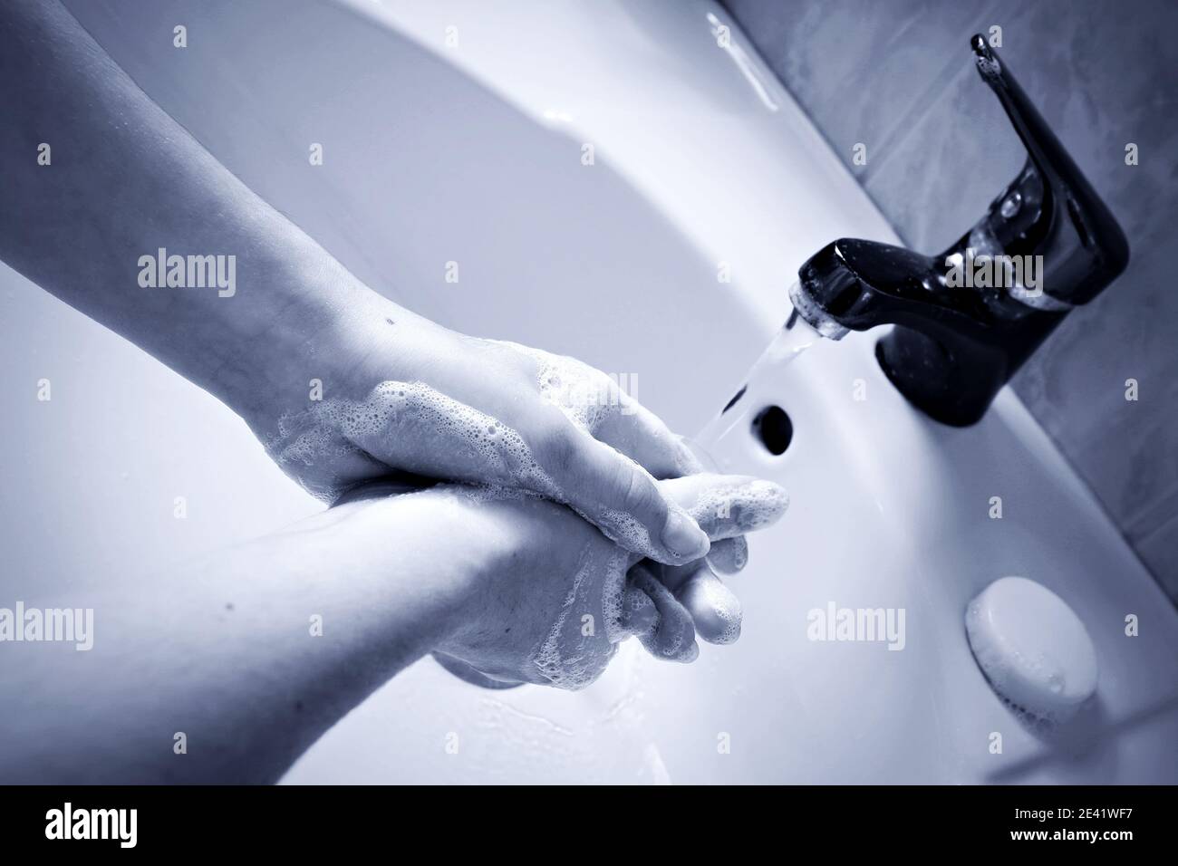 Protocollo di disinfezione sanitaria. Donna che le lava le mani con sapone antisettico e acqua calda per distruggere i germi e i batteri del virus COVID-19. Foto Stock