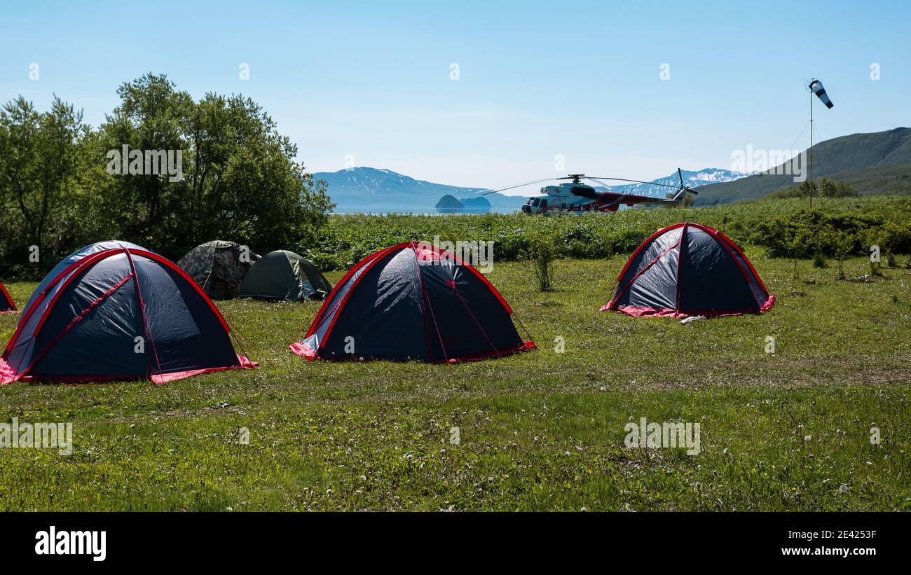 Penisola di Kamchatka, Russia - 8 luglio 2018: L'elicottero è atterrato vicino alla tenda campeggio vicino al lago Kuril, Kamchatka Foto Stock