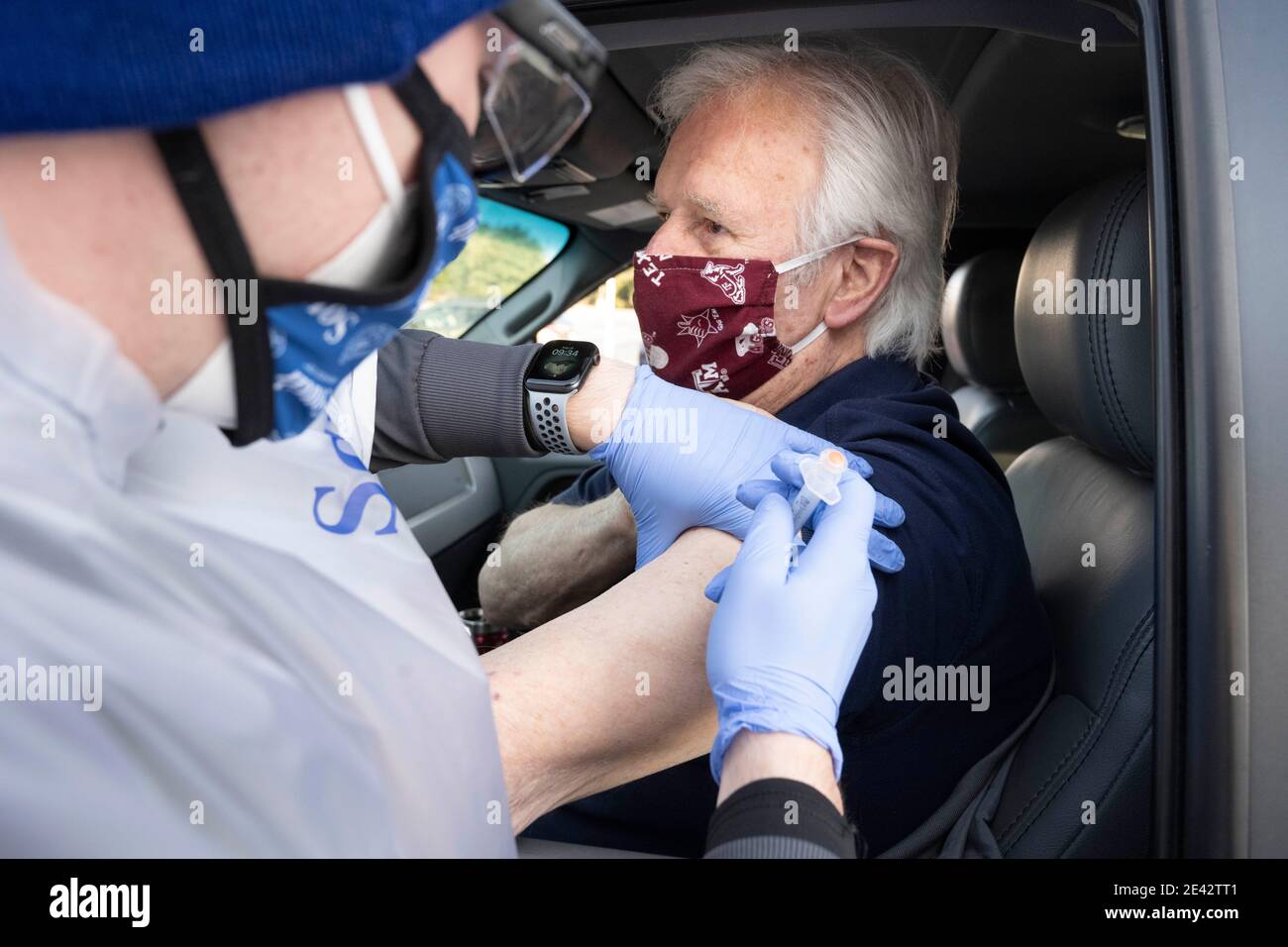 Round Rock, Stati Uniti. 21 gennaio 2021: Lo studente di infermieristica della South University Zach Beyer amministra il vaccino COVID-19 a ed McMenemy in una clinica drive-through. Più di 2,000 dosi sono state somministrate nelle braccia della gente alla clinica il giorno precedente mentre il Texas aumenta la sua risposta vaccinale. Credit: Bob Daemmrich/Alamy Live News Foto Stock