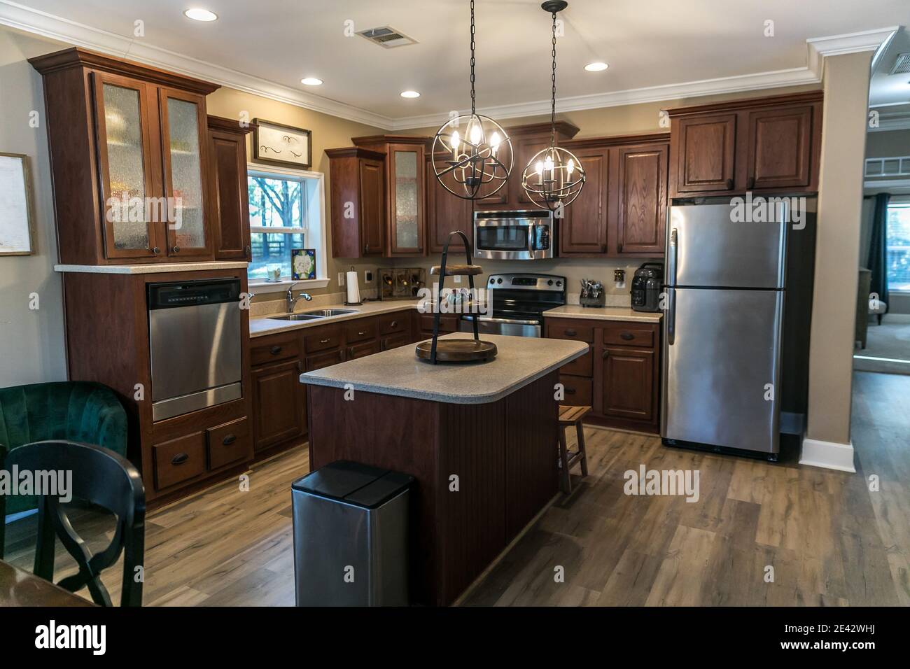 Piccola cucina rinnovata in legno scuro con isola centrale Foto Stock