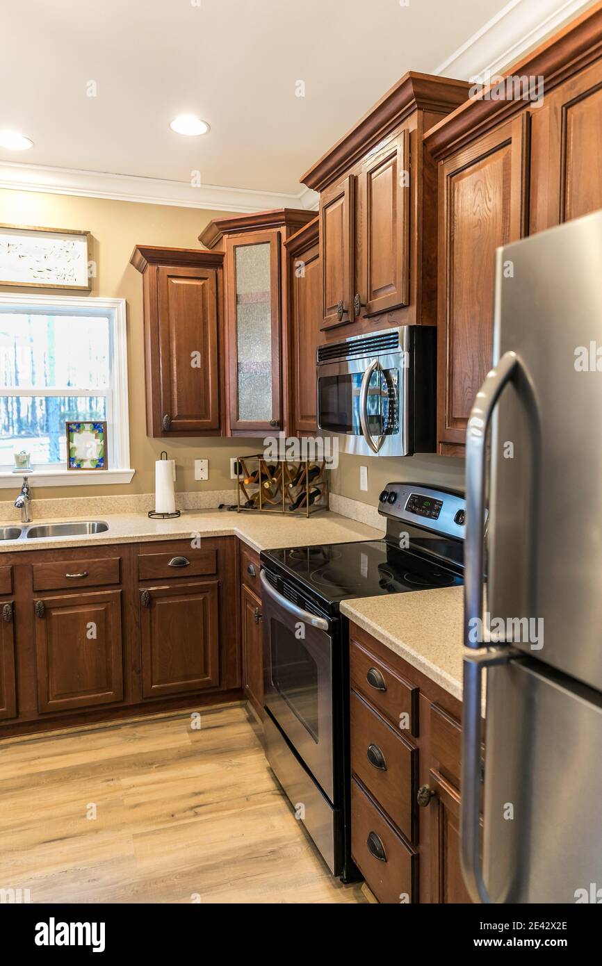 Piccola cucina rinnovata in legno scuro con isola centrale Foto Stock