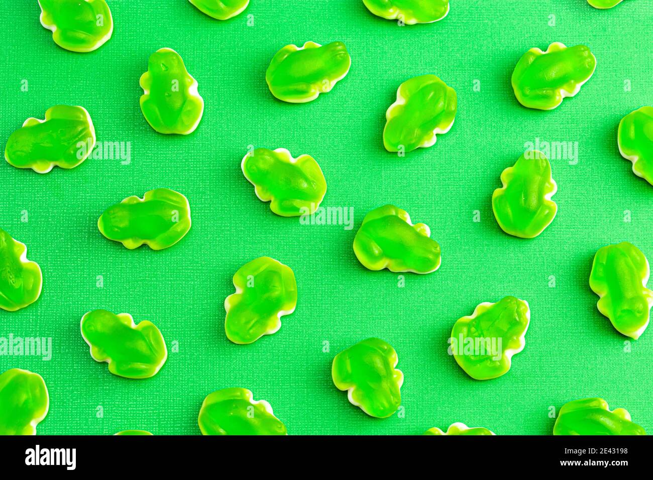 Uno sfondo di Gummy Green Frogs con una caramella Mashmallow Strato inferiore Foto Stock