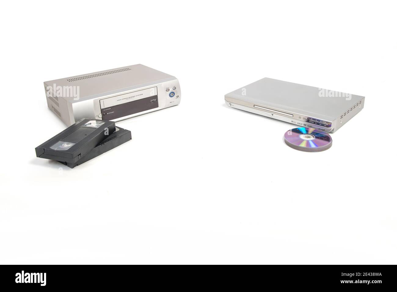 Lettore video e nastri accanto a un lettore DVD e dvd o cd isolati su sfondo bianco. Foto Stock