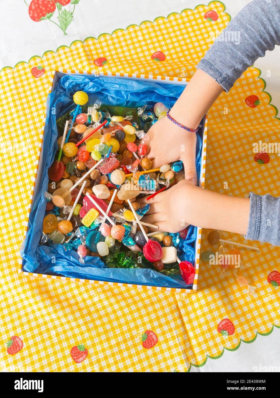 Mani all'interno di una scatola di dolci. Foto Stock