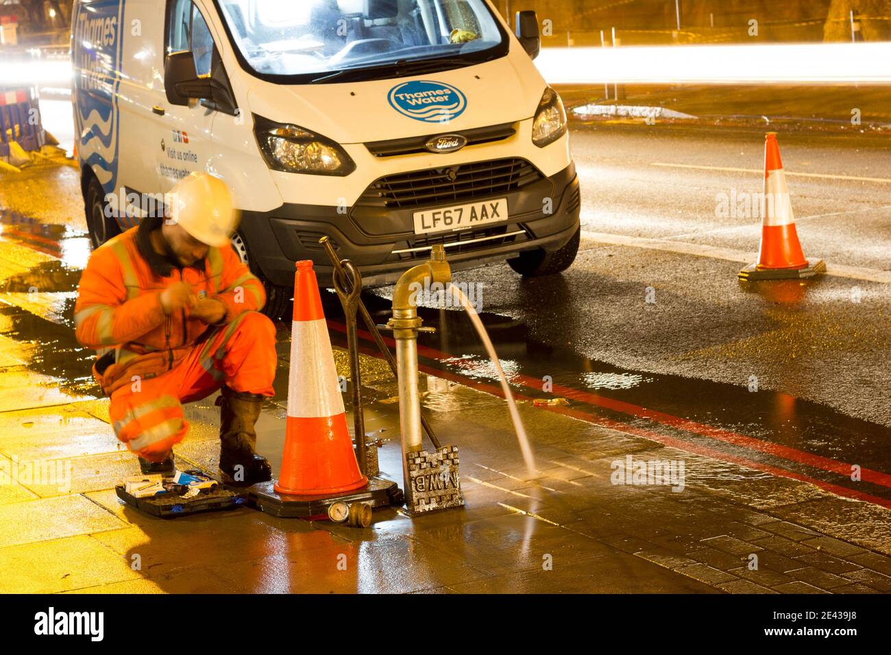 Water main burst riparato da Tamigi Water engineer a lato strada, Inghilterra Foto Stock