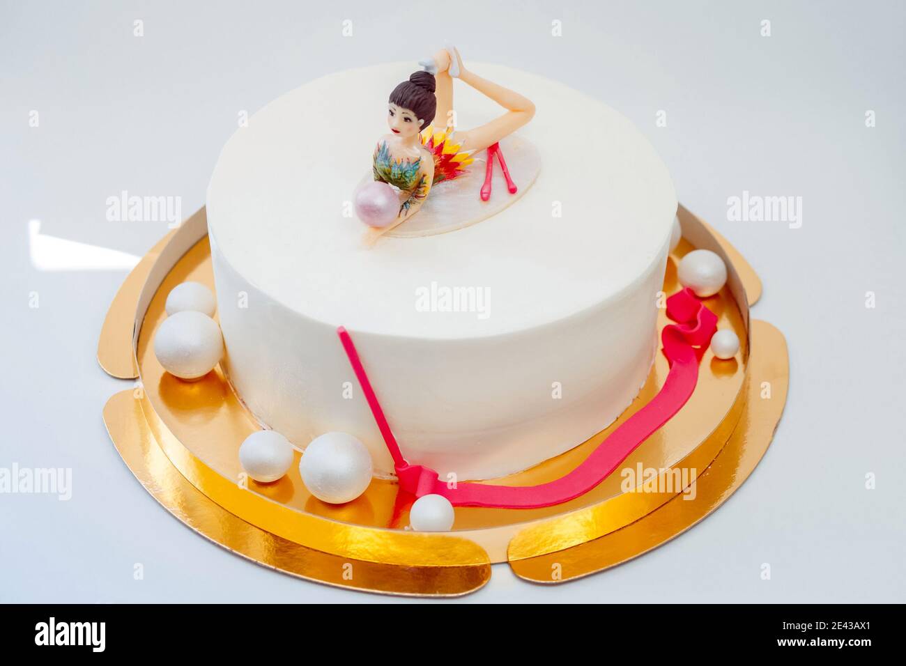 Torta bianca con la figura di un ginnasta. Torta per l'atleta. Foto Stock